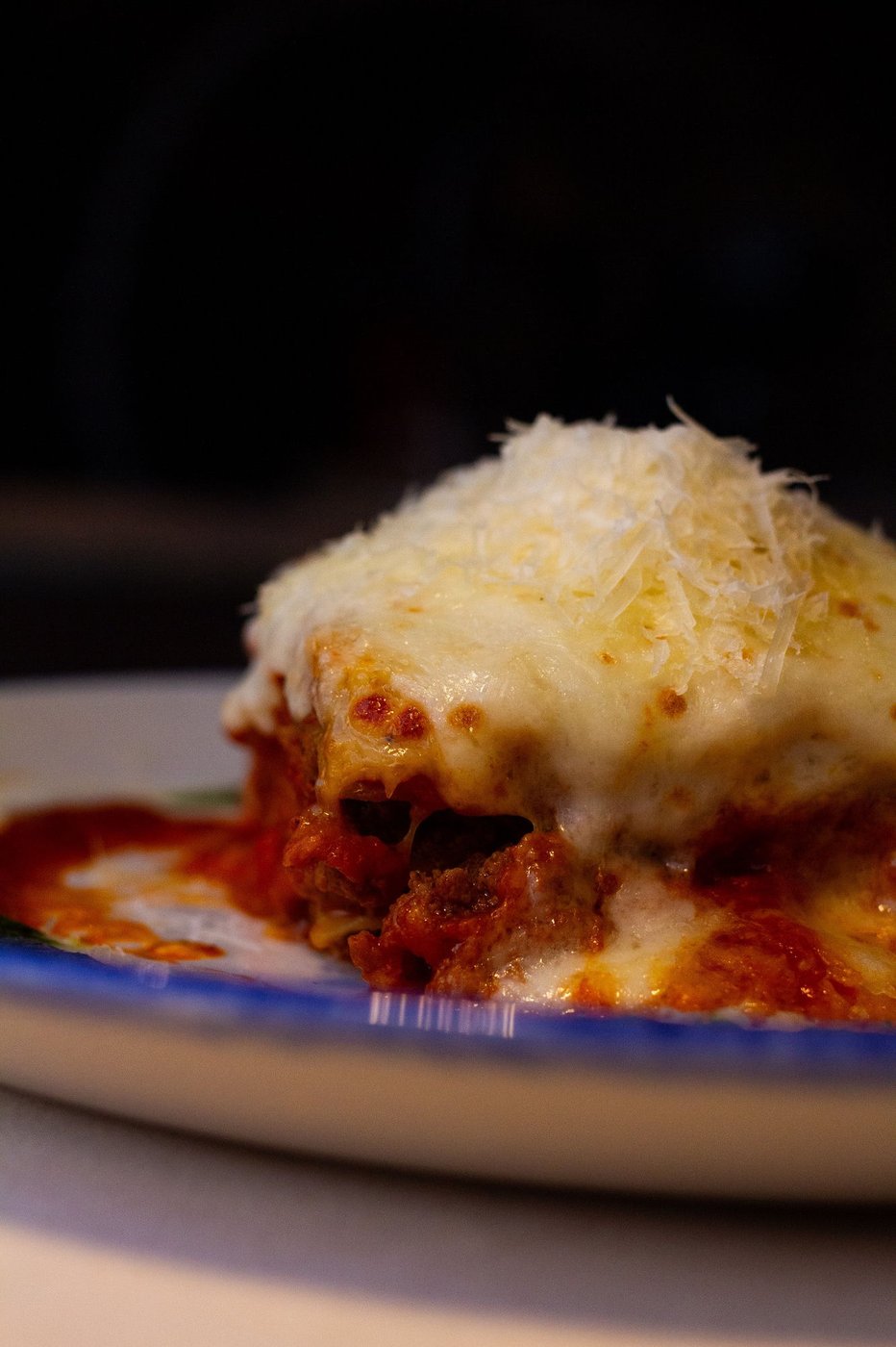 Baked lasagna topped with melted cheese and grated parmesan