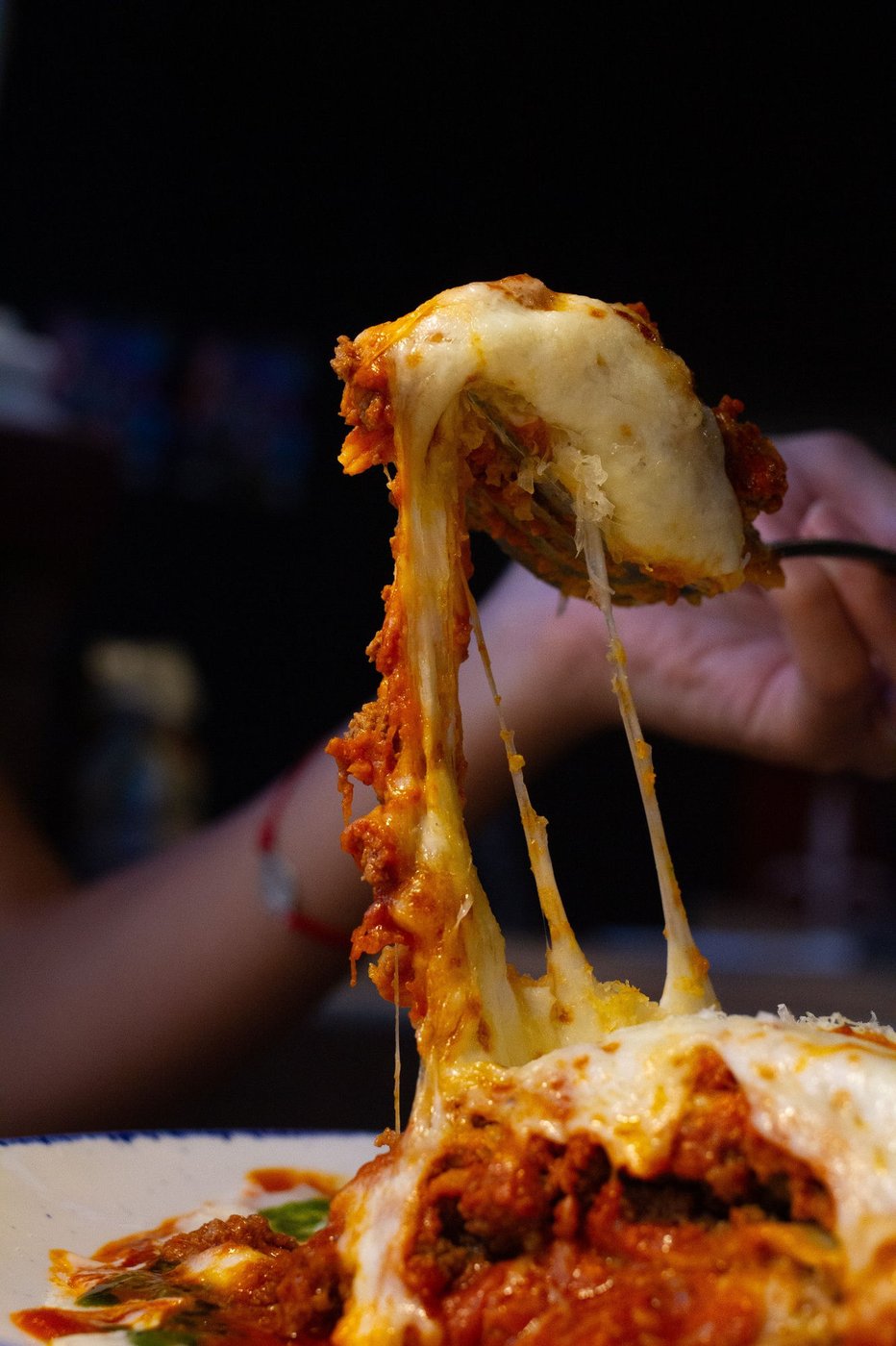 Cheese pull from a slice of freshly baked lasagna