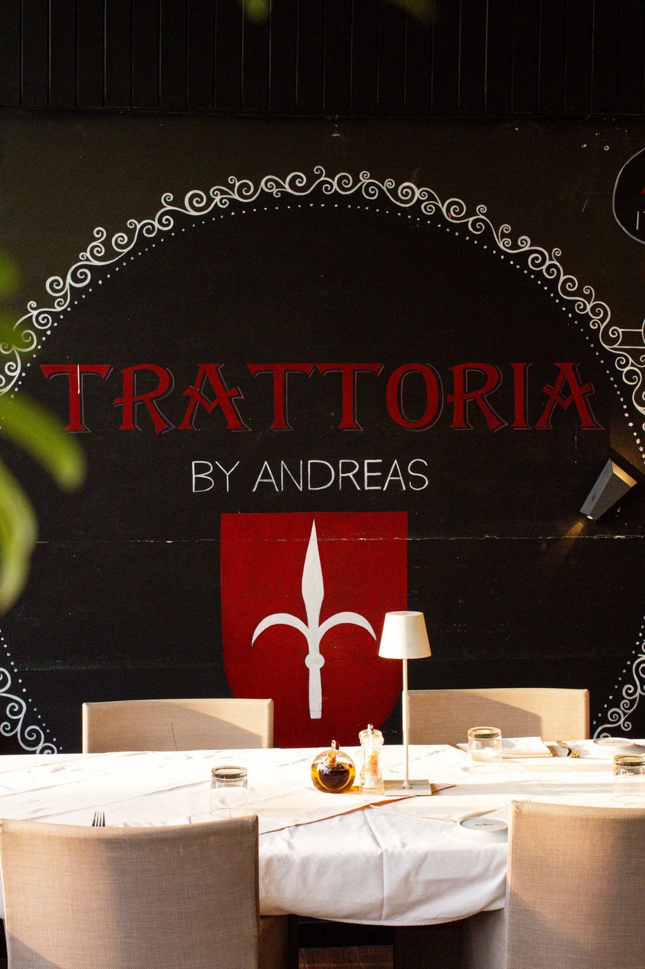 Trattoria by Andreas hand-painted wall mural above a set dining table
